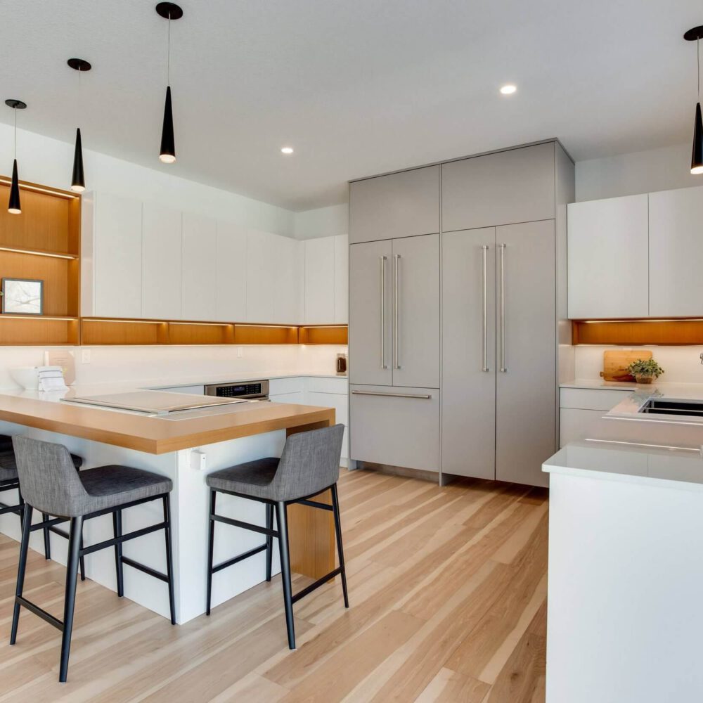 Modern kitchen with sleek cabinetry, an island with seating, and stainless steel appliances in a bright, open layout.