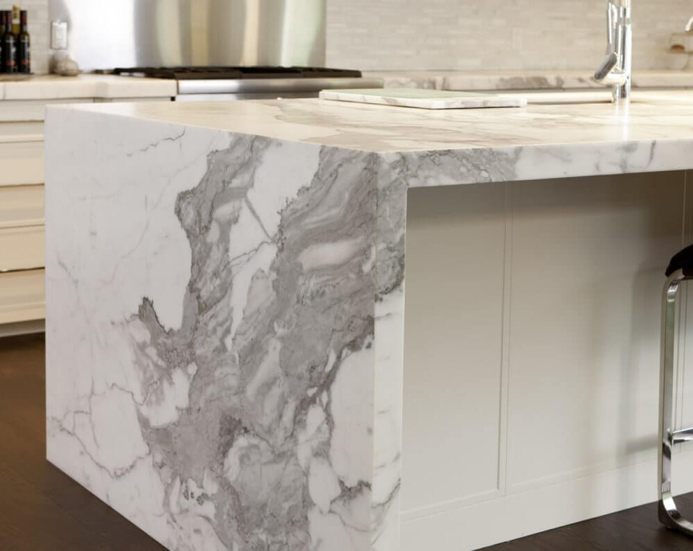 Marble kitchen island with a smooth surface and a modern design, featuring gray and white veining patterns.