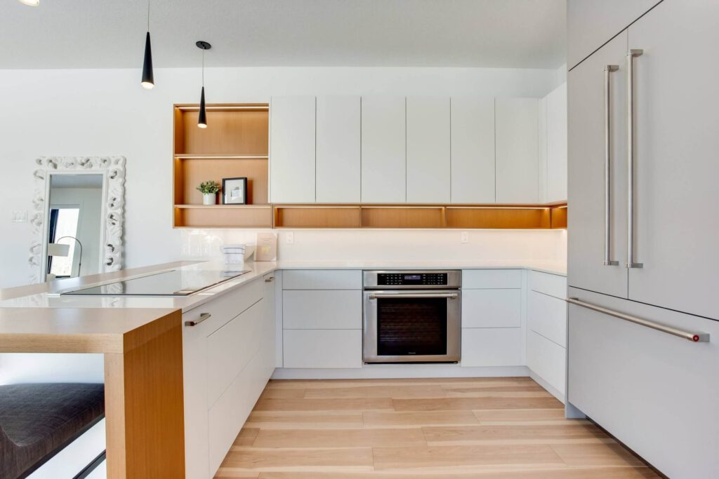 qmNA79-c Modern kitchen design featuring white cabinetry, wooden accents, and stainless steel appliances with a clean, minimalist aesthetic.